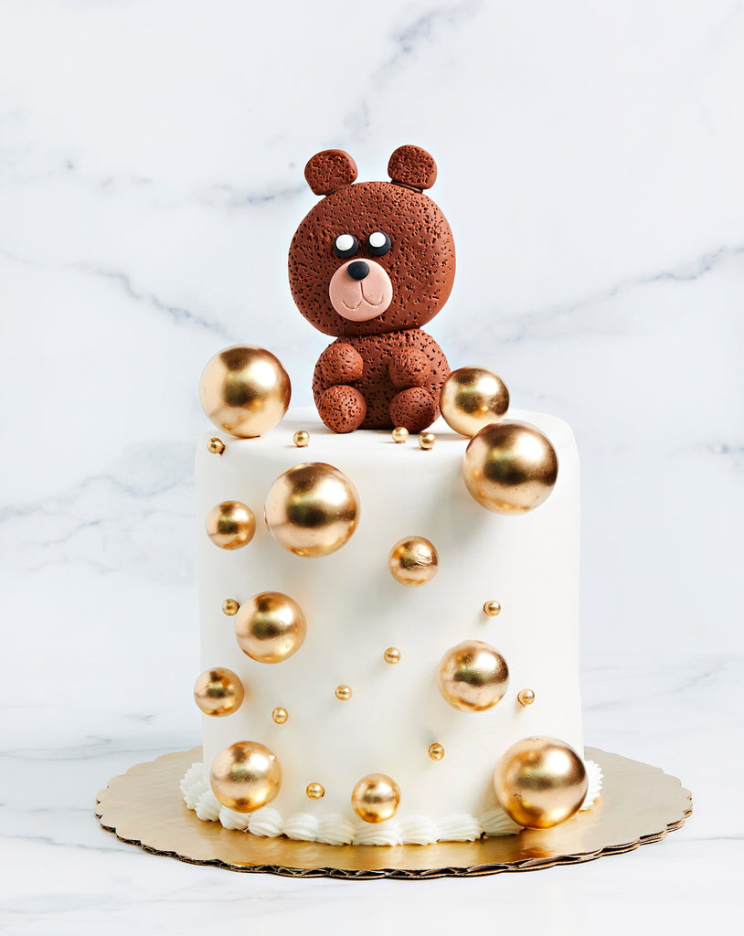 Cake with golden orbs and a cute chocolate bear