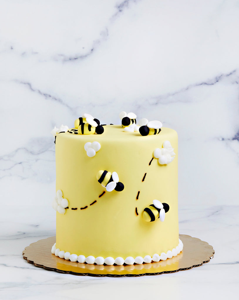 Yellow cake with cute honey bees buzzing around