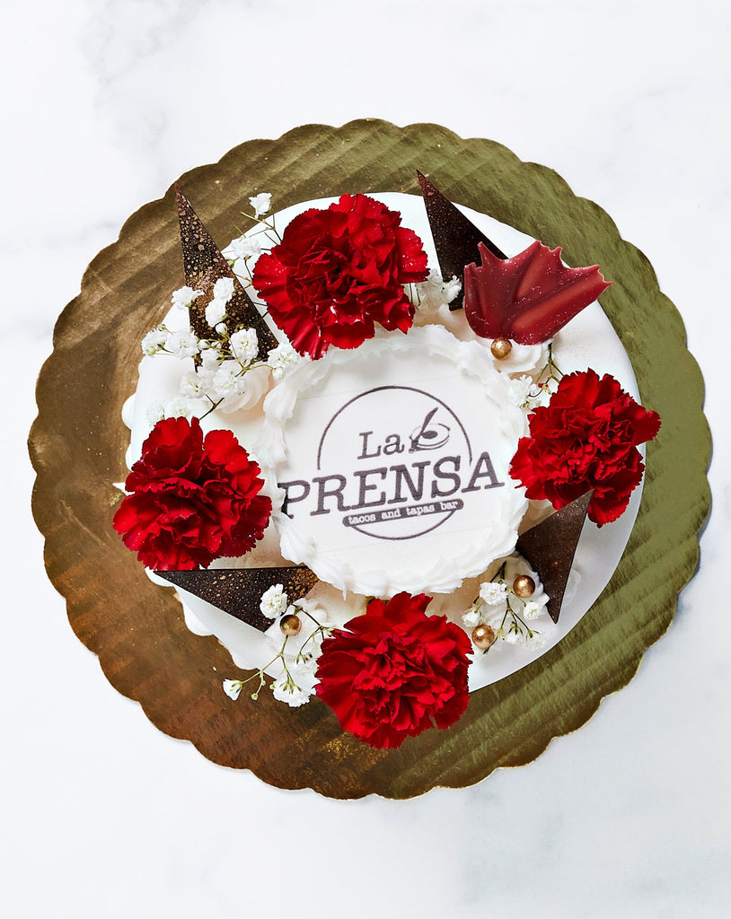 Top view of cake with fresh flowers and custom edible logo